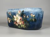 un vase bleu orné de fleurs, posé sur une table