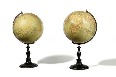 trois globes anciens empilés les uns sur les autres sur une surface blanche