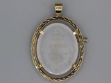 a close up of a gold pendant with a picture of a woman