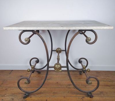 une table au plateau en marbre posée sur un parquet