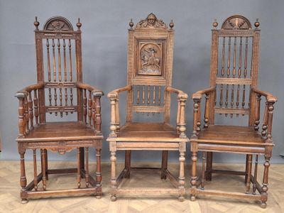 three wooden chairs with carved back and arms are sitting on a wooden floor