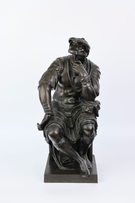 statue en bronze représentant un homme assis sur un tabouret, les mains posées sur les genoux