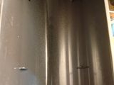 a metal sink that has a bottle of water in it