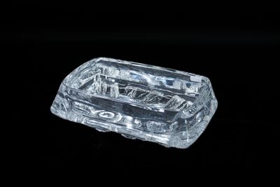 un objet en verre transparent posé sur une surface noire