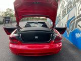 a red car with its trunk open in a parking lot