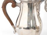 une cafetière en argent avec une poignée en bois sur fond blanc
