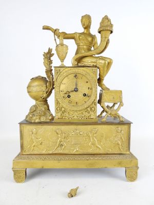 une horloge en or sur laquelle est assis un homme