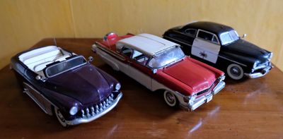 trois petites voitures posées sur une table