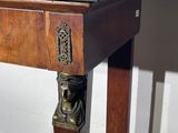 a small wooden table with a black top on a wooden floor