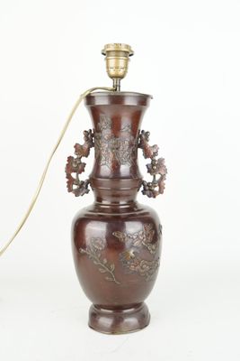 un vase marron avec une anse dorée sur fond blanc