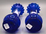 two blue vases with tags on them sitting on a table