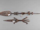 three old iron tools are displayed on a gray surface