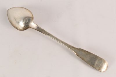 a spoon that is sitting on a white surface