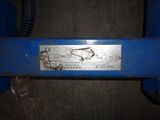 a close up of a blue machine with a metal plate on it