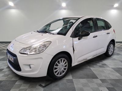 la petite voiture blanche est garée sur un sol en damier