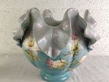 a blue vase with flowers on it sitting on a table