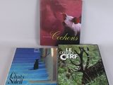 Trois livres sont posés sur une surface blanche ; l'un représente un cochon et l'autre un chat.