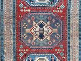 a red, blue and green rug with geometric design
