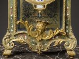 a gold clock with a blue face on a marble table