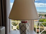 une lampe posée sur une table devant une fenêtre