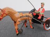 a figurine of a man riding in a horse drawn carriage