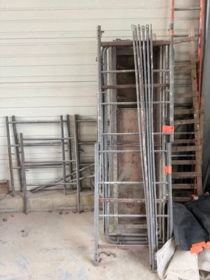 a pile of chairs and a ladder in a garage