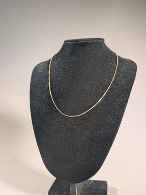 necklace on a mannequin stand on a white background