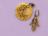 une breloque en forme de main de Hamsa plaquée or et une pièce d'or sur fond violet