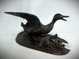 bronze sculpture of a duck and ducklings on a wooden base