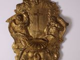 a gold plaque with a cross on it on the wall