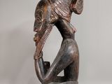 an image of a wooden sculpture of a man with a fish on his head