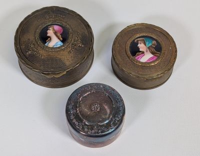 deux petites boîtes en métal sur lesquelles figurent les photos d'une femme et d'un homme