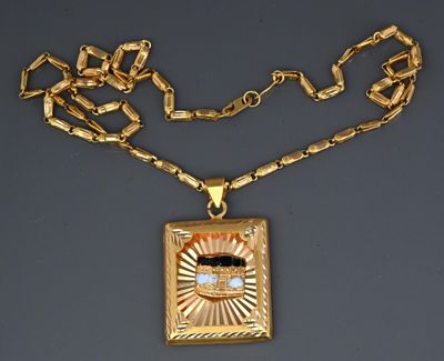 an image of a gold necklace with a square pendant with a diamond in the center