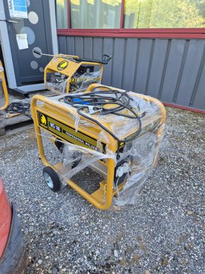 two portable generators sitting on top of a gravel ground next to a red fire hydrant