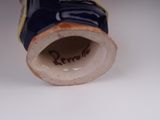 a close up of a blue and white vase on a table