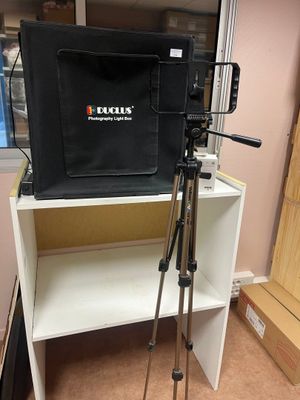 un appareil photo posé sur un trépied à côté d'une bibliothèque