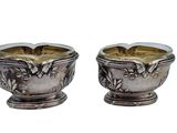 pair of silver plated bowls with flowers and leaves on them