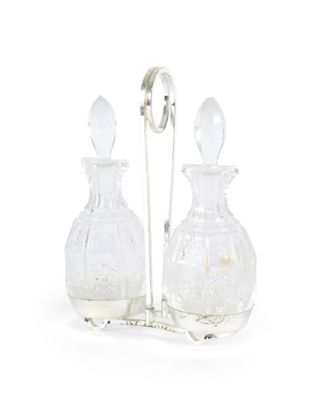paire de carafes en verre transparent posées sur un socle et dotées d'une poignée en argent