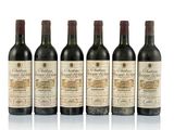 six bottles of wine are lined up on a white surface