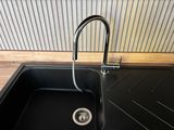 a black sink with a chrome faucet in it