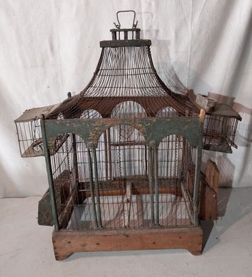 une cage à oiseaux dans laquelle se trouve un oiseau