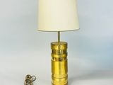 a brass table lamp with a white shade on top of it