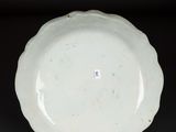 a close up of a white plate on a black surface