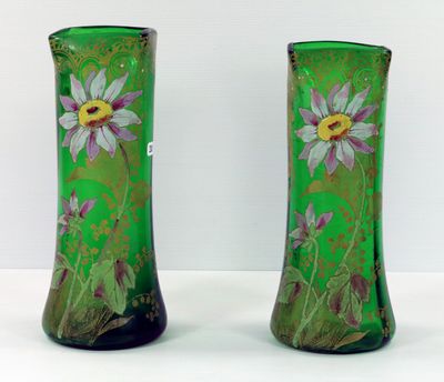 une paire de vases verts ornés de fleurs violettes, posés sur un fond blanc