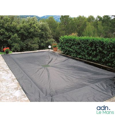 une bâche noire recouvrant une piscine dans un jardin