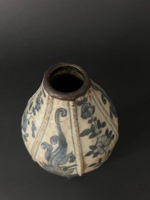 a blue and white vase sitting on a black surface