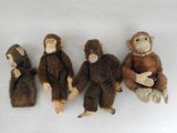 trois singes en peluche assis les uns à côté des autres sur une surface blanche