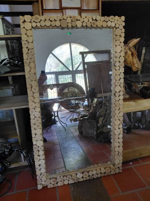 a large mirror made out of logs on the floor