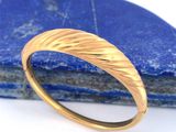 un gros plan d'une bague en or sur laquelle est sertie une pierre bleue