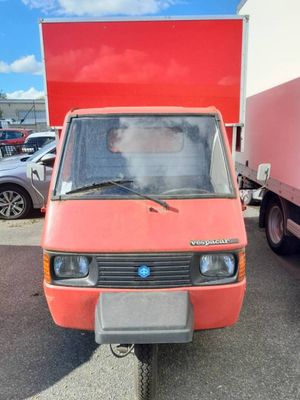 a small orange car parked in a parking lot